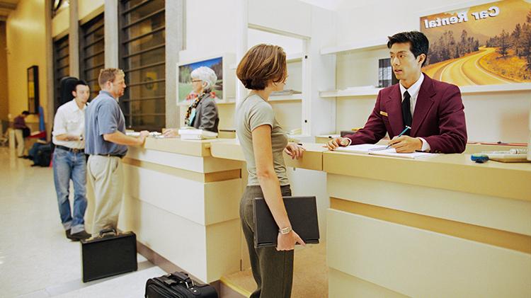 Customer at a car rental counter discussing car rental insurance.